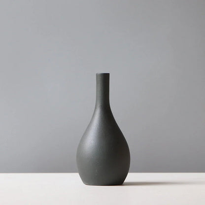 Ceramic vase in various colours, including brown, black, green, and orange, showcasing a minimalist Scandinavian design that is perfect for living room decor.