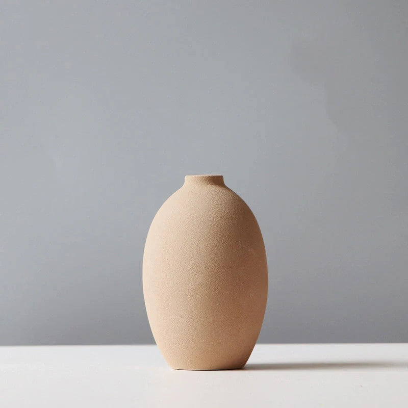 Ceramic vase in various colours, including brown, black, green, and orange, showcasing a minimalist Scandinavian design that is perfect for living room decor.
