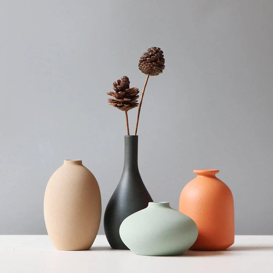 Ceramic vase in various colours, including brown, black, green, and orange, showcasing a minimalist Scandinavian design that is perfect for living room decor.
