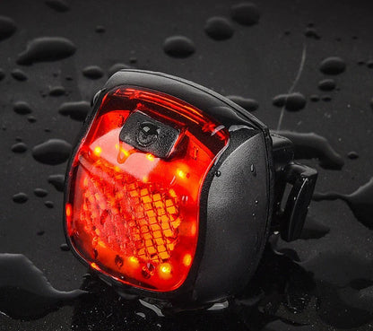Rechargeable bicycle tail light with 5 adjustable lighting modes, made of durable ABS plastic for scratch and impact resistance.
