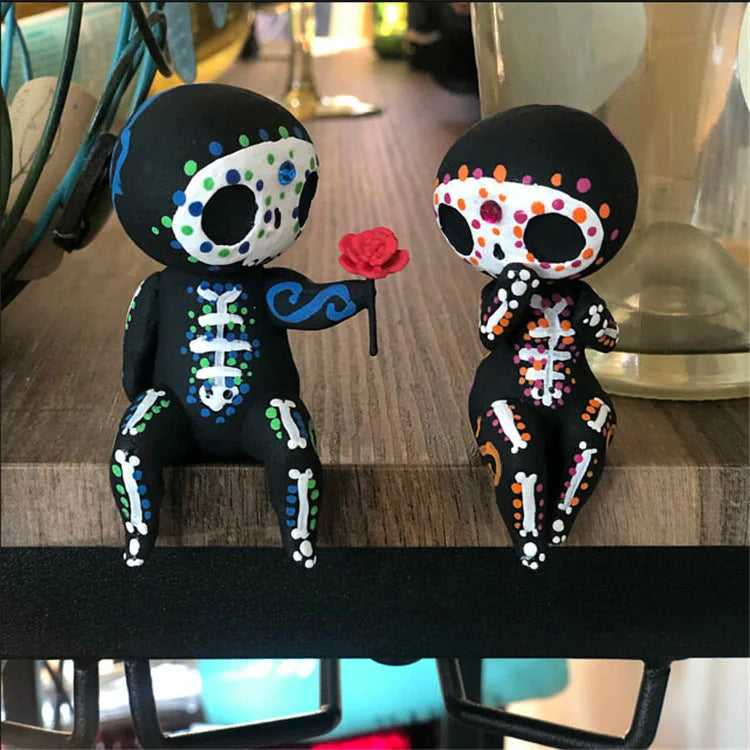 Customisable sugar skull couple figurine sitting on a ledge with legs dangling