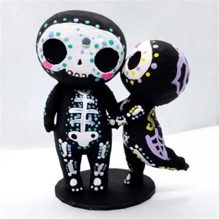 Customisable sugar skull couple figurine sitting on a ledge with legs dangling