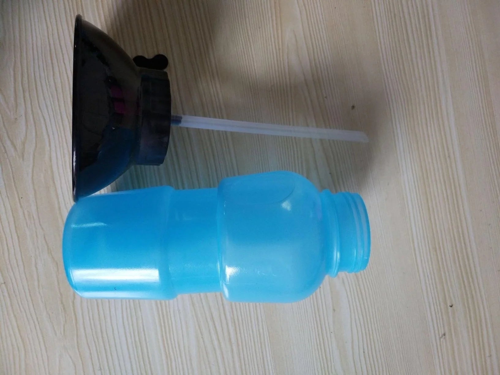Portable pet water bottle with squeeze-feed bowl for dogs and cats