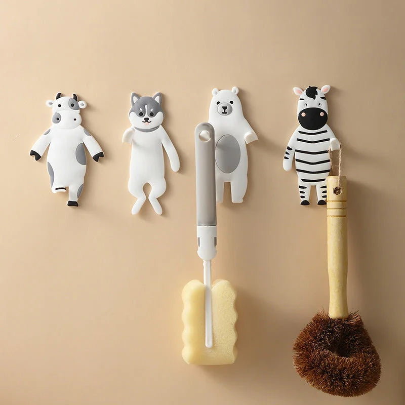 Assorted animal-shaped wall hooks in various colours, including bear, zebra, and cow designs, displayed on a white background
