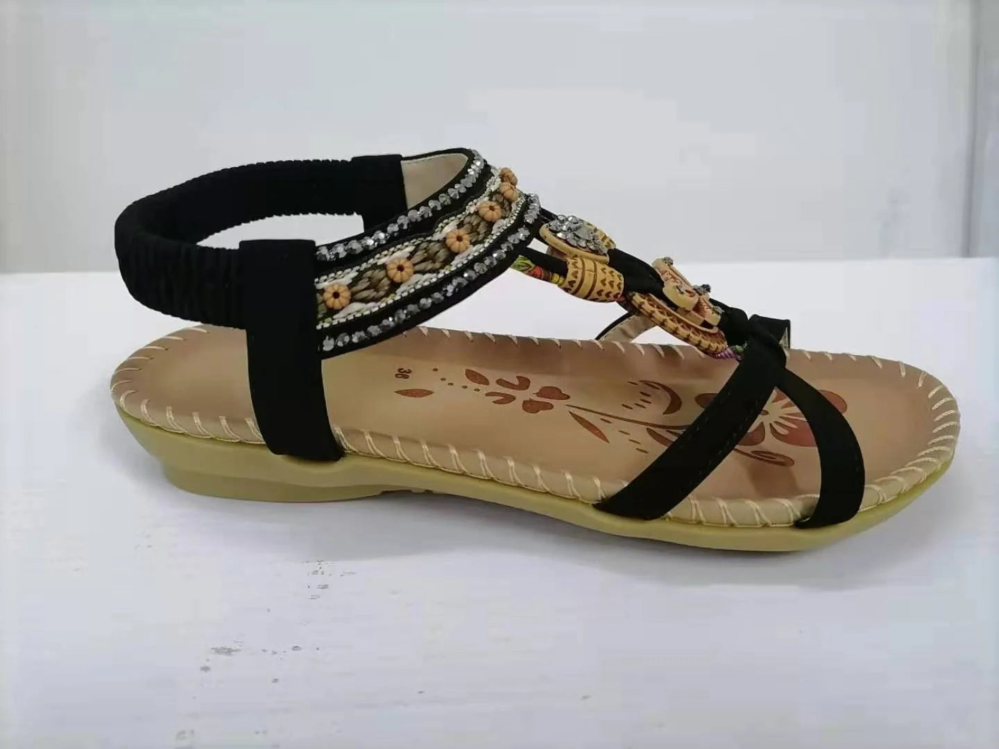 Women's flat sandals with flower rhinestone detail in black, royal blue, apricot, and brown