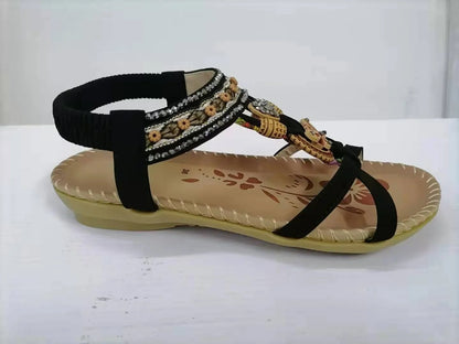 Women's flat sandals with flower rhinestone detail in black, royal blue, apricot, and brown