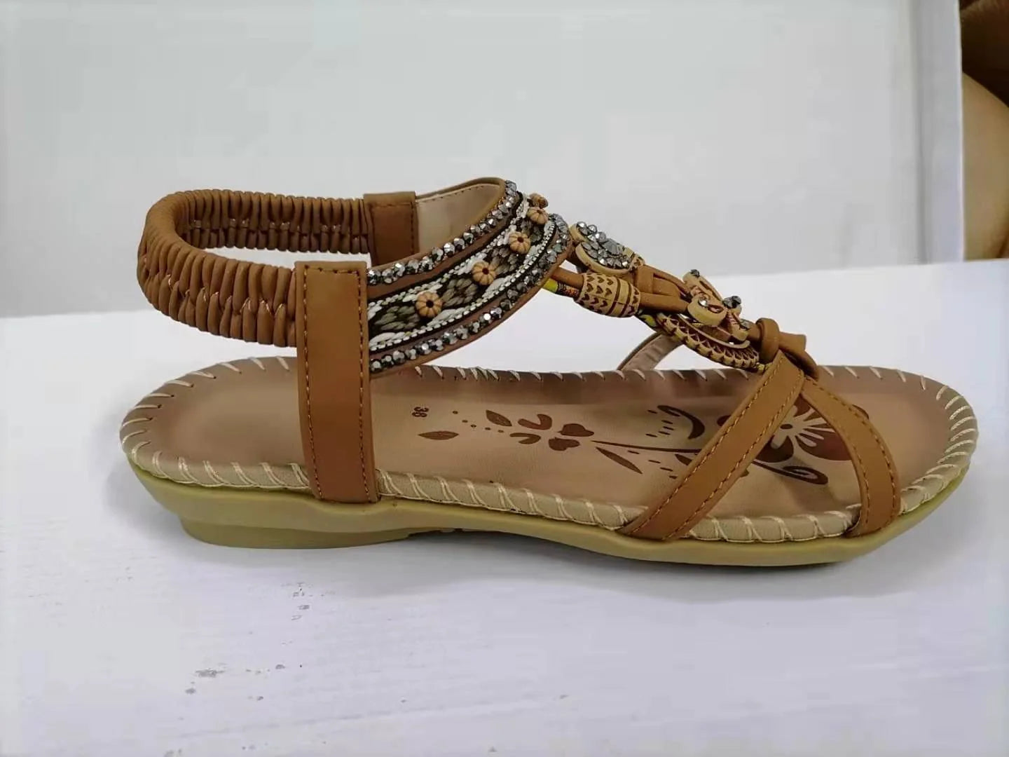 Women's flat sandals with flower rhinestone detail in black, royal blue, apricot, and brown