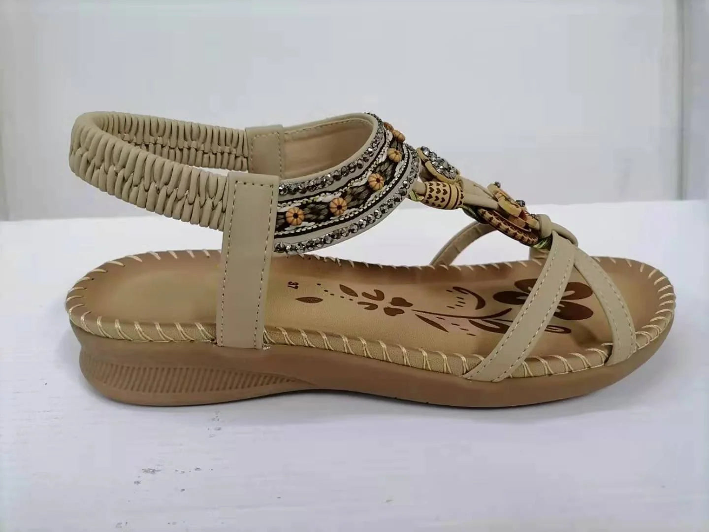 Women's flat sandals with flower rhinestone detail in black, royal blue, apricot, and brown
