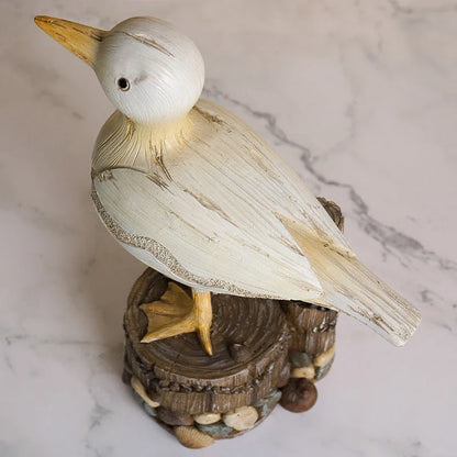 Resin seagull statue perched on a weathered wooden stump, bringing coastal charm to any indoor or outdoor space