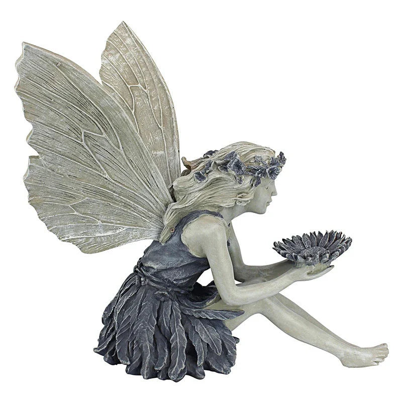 A beautiful resin fairy garden statue with a flower crown and petal skirt, holding a sunflower bowl to attract birds