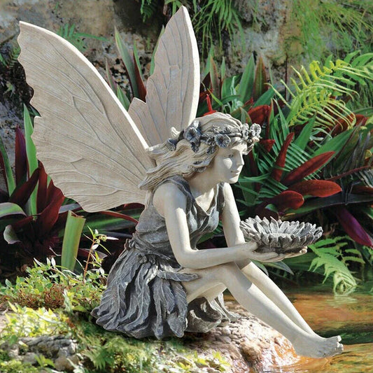 A beautiful resin fairy garden statue with a flower crown and petal skirt, holding a sunflower bowl to attract birds