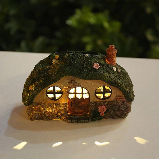 Solar-powered fairy house lamp with warm, inviting glow for outdoor garden decor