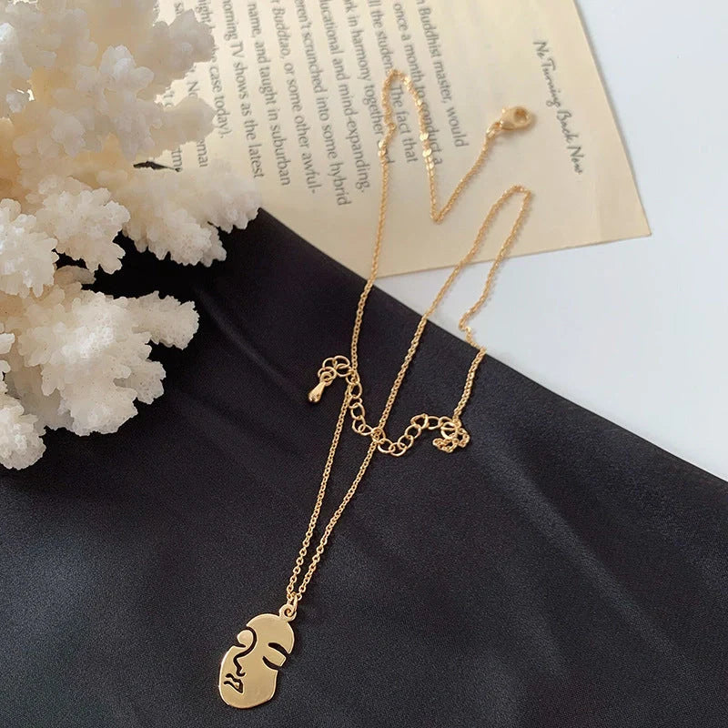 Gold alloy abstract face choker necklace with geometric pendant and adjustable chain