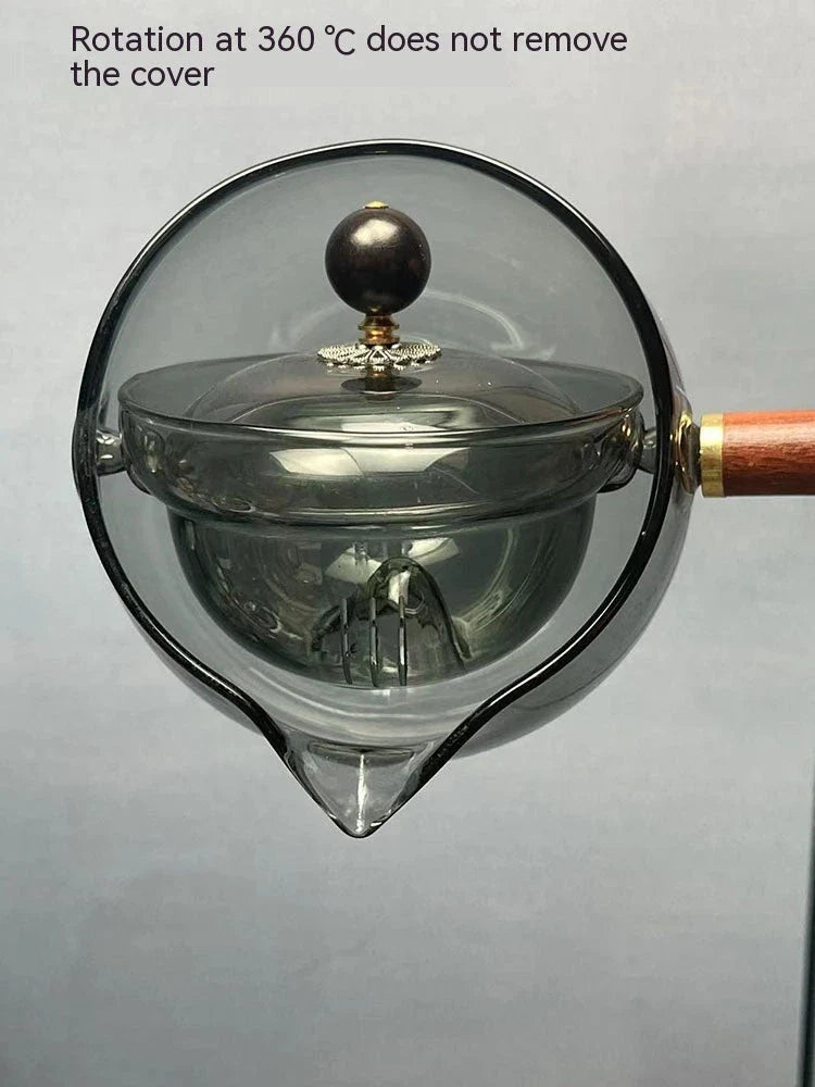 Elegant rotating glass teapot with a wooden handle, designed for a perfect tea-making experience