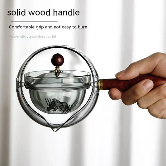 Elegant rotating glass teapot with a wooden handle, designed for a perfect tea-making experience