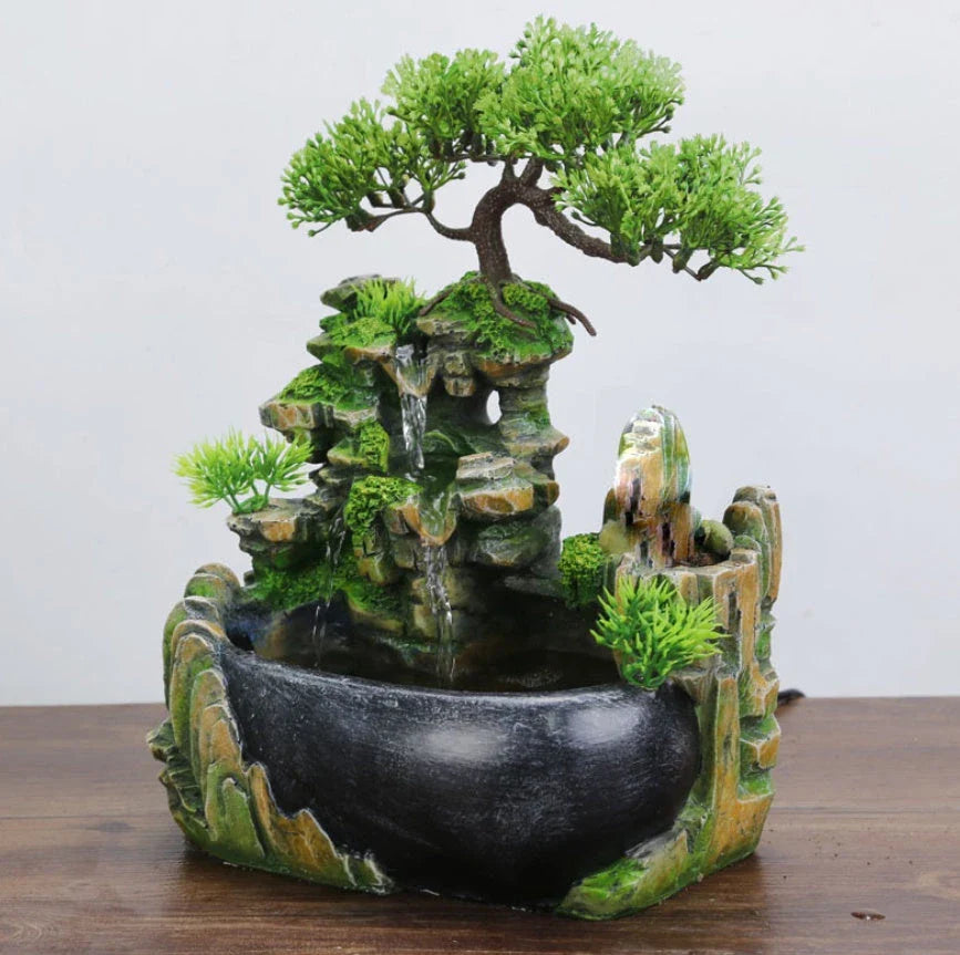 A desktop water feature with a rockery design, flowing water, and an optional mist function for creating a calming and relaxing ambience in home or office spaces.