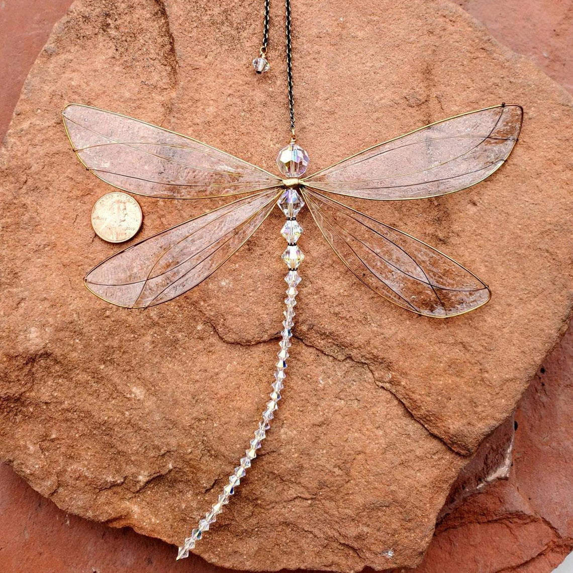 Dragonfly-shaped crystal suncatcher that creates a vibrant rainbow display when exposed to sunlight, perfect for garden, wedding and home decor