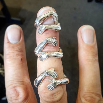 Elegant Adjustable Love Hands Embracing Ring in gold and silver, a perfect symbol of affection