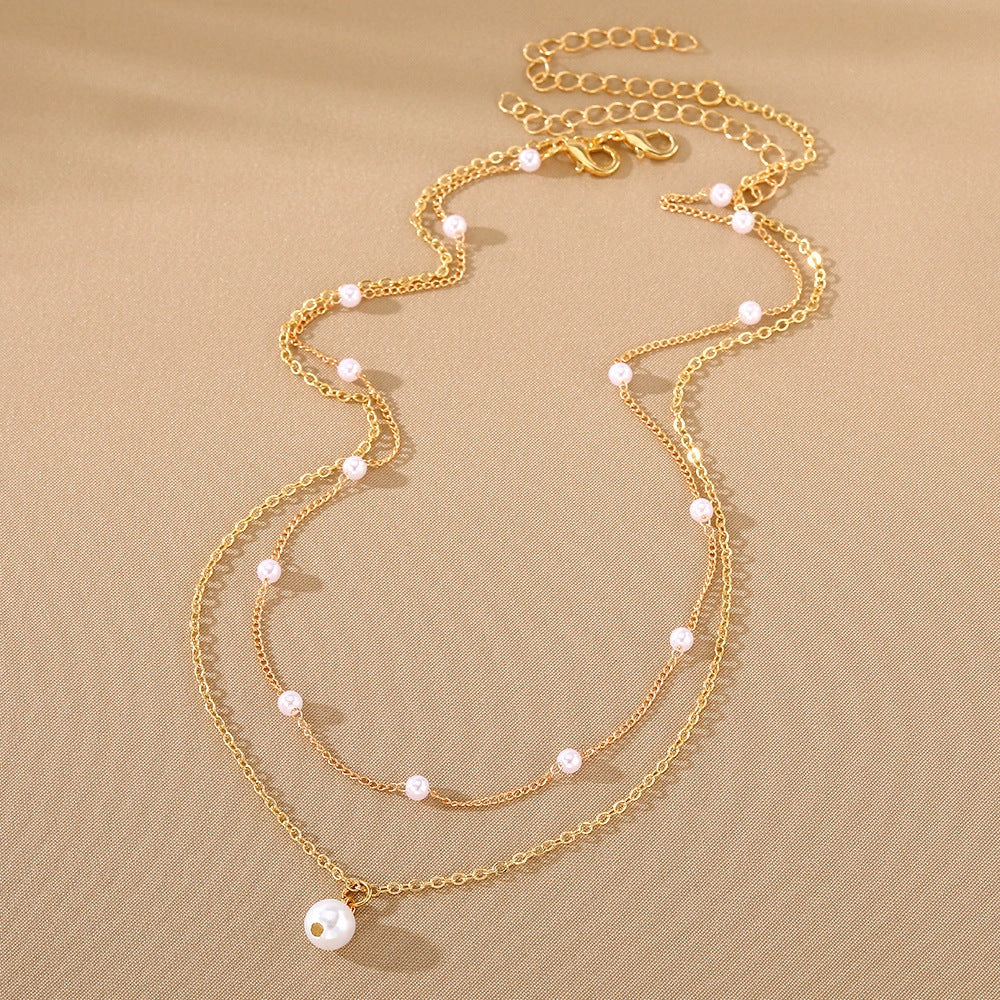 Elegant pearl and tassel double-layer necklace in gold tone, a timeless accessory for discerning women