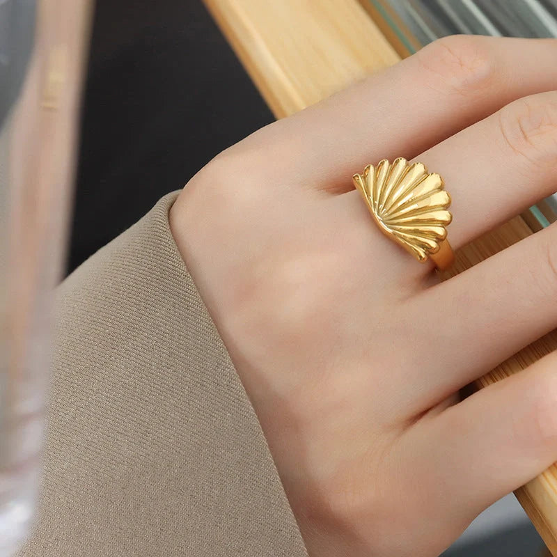 Ocean Style Scallop Ring in titanium steel and gold finishes, showcasing geometric design inspired by the sea.