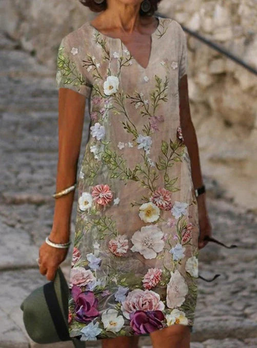 A floral printed midi dress made from a cotton-linen blend fabric, featuring a V-neck and short sleeves.