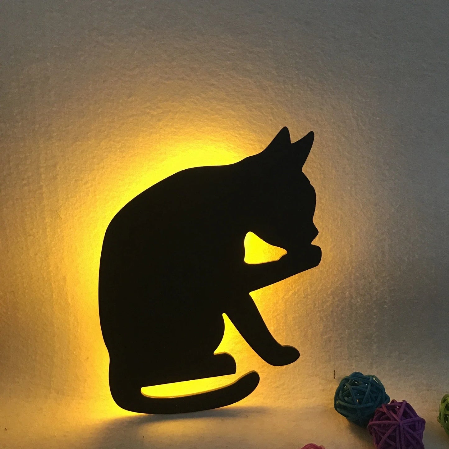 A stylish cat-shaped smart sensor night light that automatically illuminates a room when motion is detected, creating a warm and cozy atmosphere.
