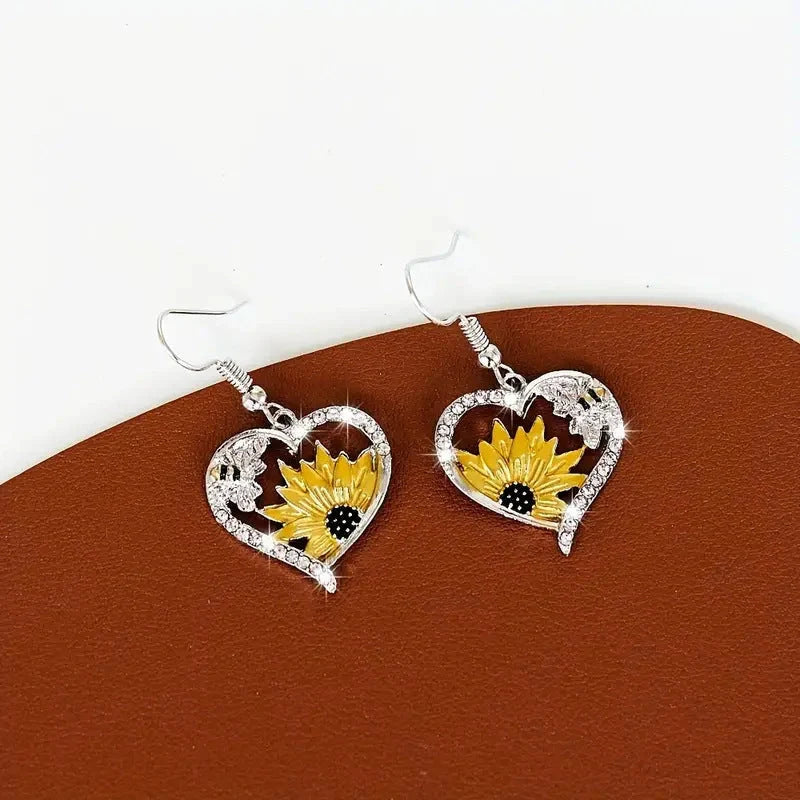 Elegant silver earrings featuring delicate bee and sunflower motifs, a stunning fashion accessory with natural charm.