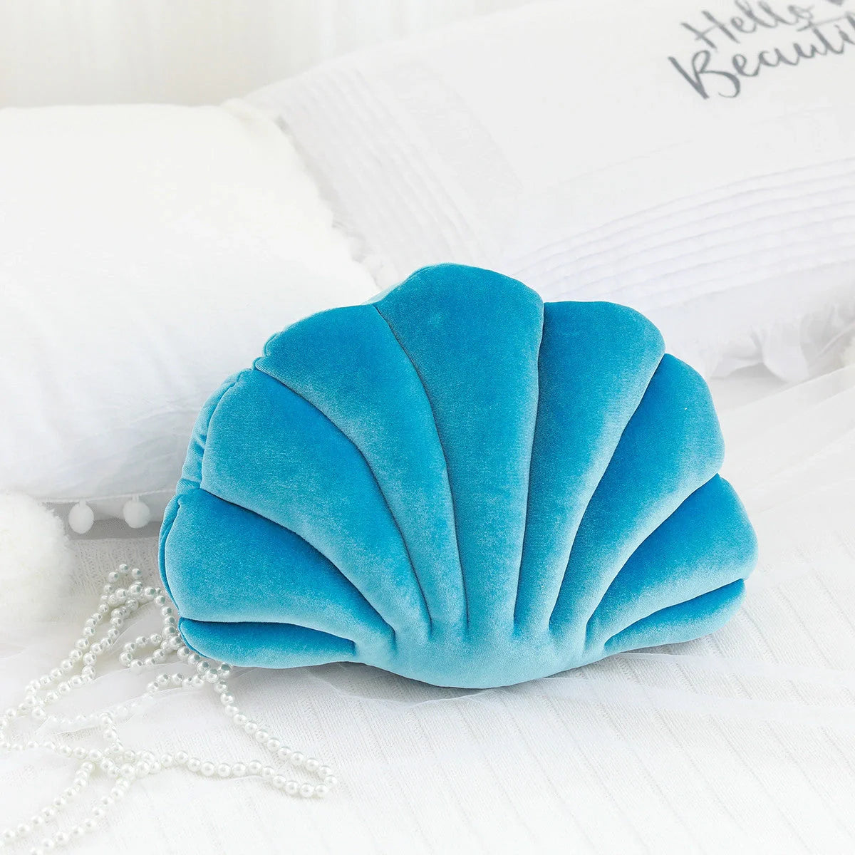 Cosy shell-shaped plush nap pillow in various colours and sizes for ultimate comfort