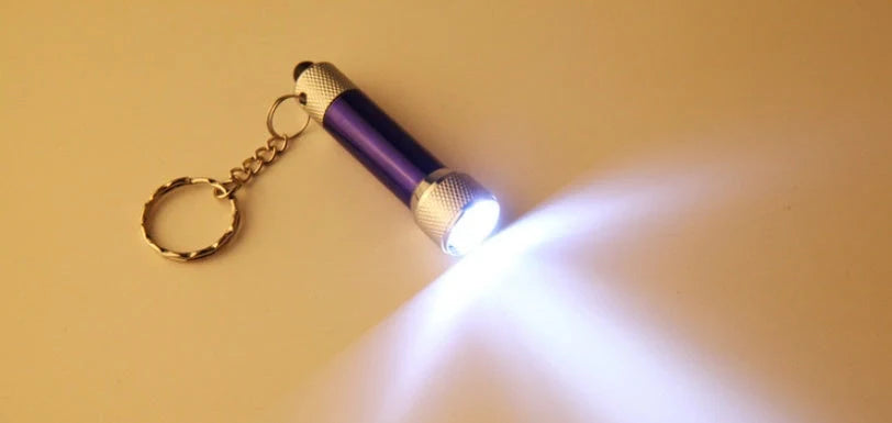 Compact LED keychain torch in four colours for emergencies and camping