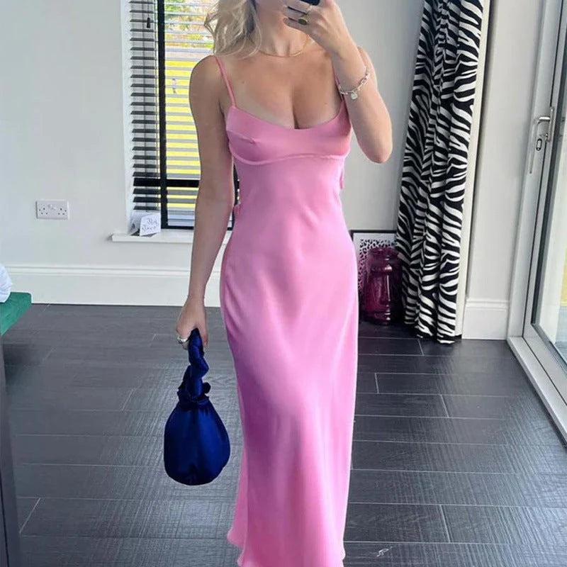 A sleek and elegant satin slip dress in a stunning pink color with a backless design and full-length silhouette.