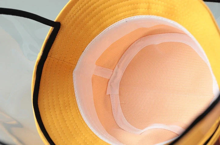 Child wearing anti-spitting protective hat with transparent bezel