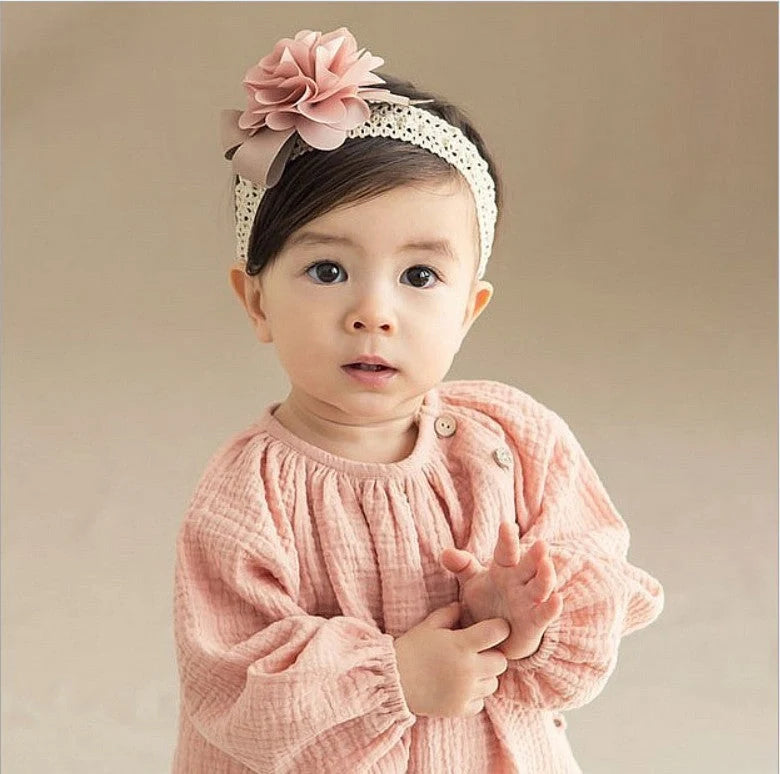 A beautiful floral headband for babies, featuring delicate flowers and a comfortable, adjustable design.