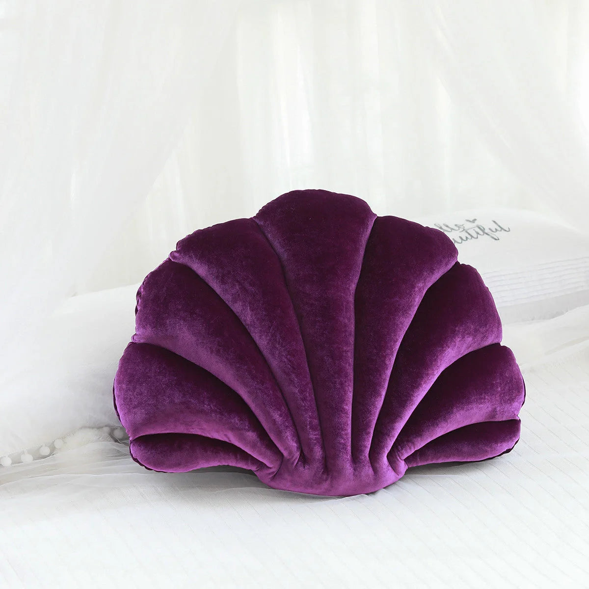 Cosy shell-shaped plush nap pillow in various colours and sizes for ultimate comfort