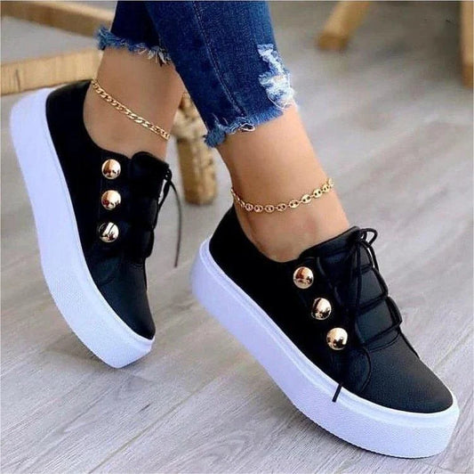 Women's lace-up flats with rivet detailing in white, black, gold, and rose gold