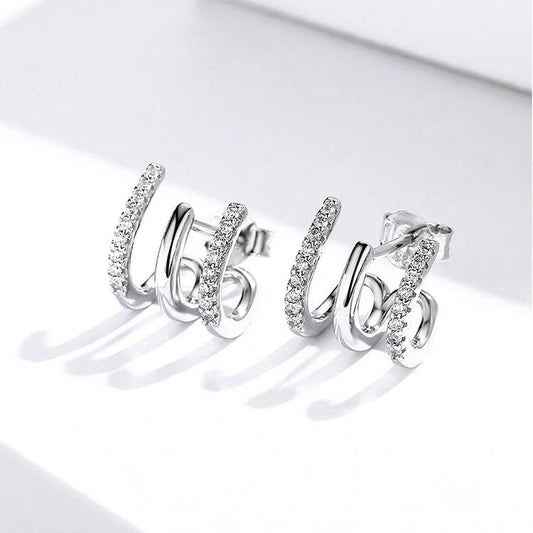 Elegant three-layer sterling silver heart earrings with sparkling gems, perfect for any occasion.