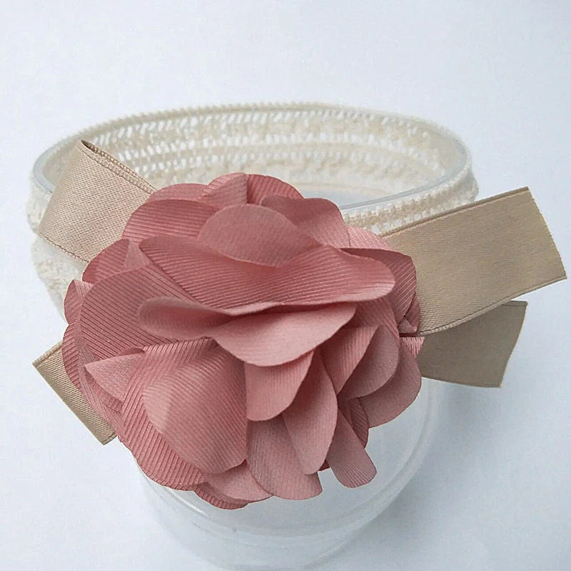 A beautiful floral headband for babies, featuring delicate flowers and a comfortable, adjustable design.