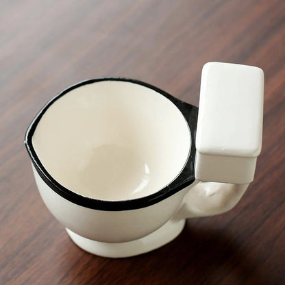 Toilet-shaped ceramic mug with handgrip, perfect for coffee or tea, holding 280ml.