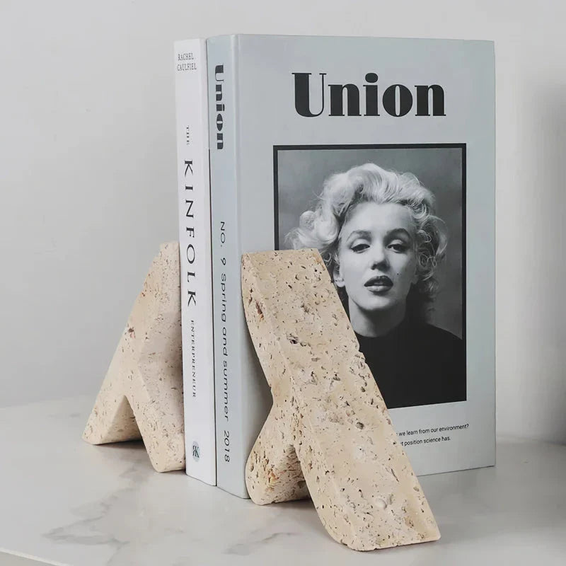 Elegant beige travertine stone bookends providing stable support for books and decor on a wooden shelf