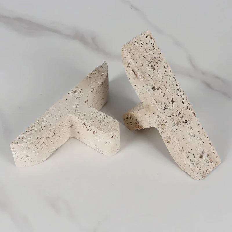 Elegant beige travertine stone bookends providing stable support for books and decor on a wooden shelf