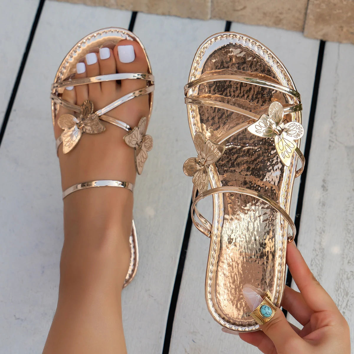 Women's butterfly cross-strap sandals in black, silver, gold, and champagne colours