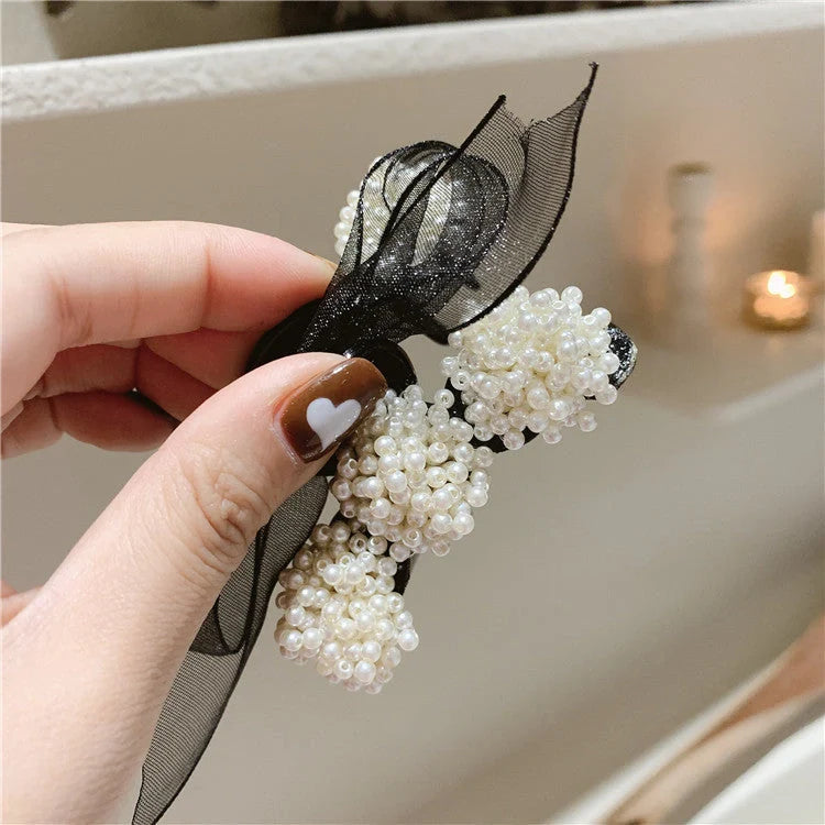 Korean pearl bow hair clip in black, alloy construction for durability and style.
