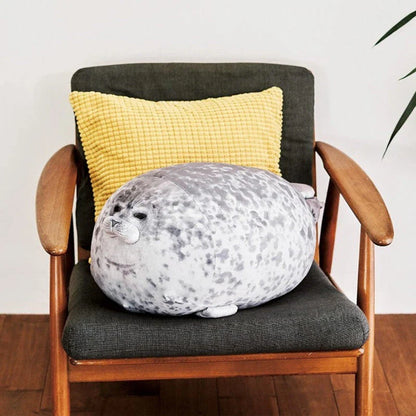 A plush, soft, and cuddly grey or white seal-shaped cushion with a detailed, lifelike design
