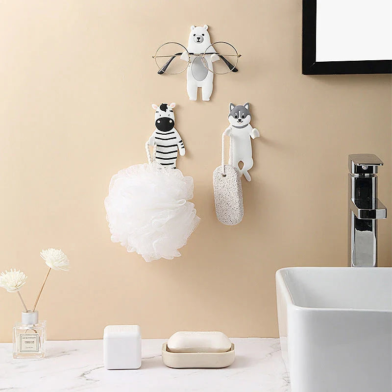 Assorted animal-shaped wall hooks in various colours, including bear, zebra, and cow designs, displayed on a white background