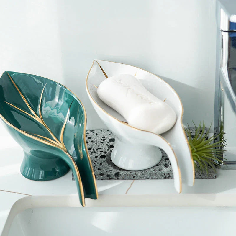 Elegant ceramic soap dish with leaf-shaped design, suction cup base, and drainage holes for bathroom storage and decor