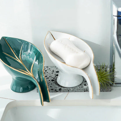 Elegant ceramic soap dish with leaf-shaped design, suction cup base, and drainage holes for bathroom storage and decor