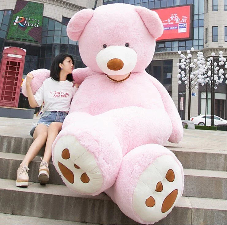 Colossal plush teddy bear in various sizes and colors, including light brown, dark brown, gray, white, pink, and purple