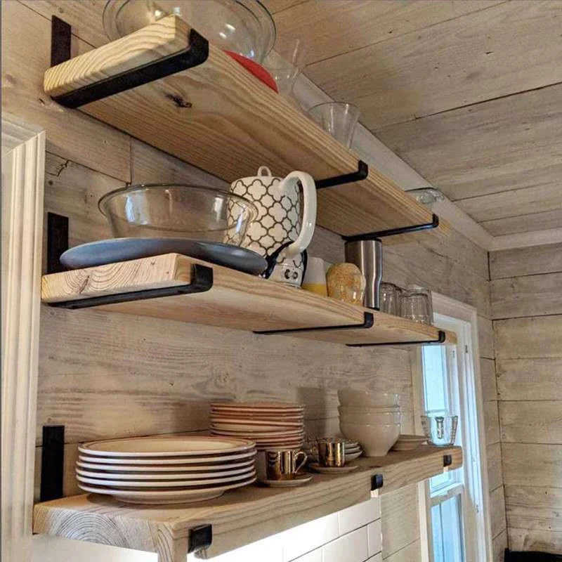 Sturdy black iron wall shelves in three sizes for displaying books, decor, and more in a rustic home setting