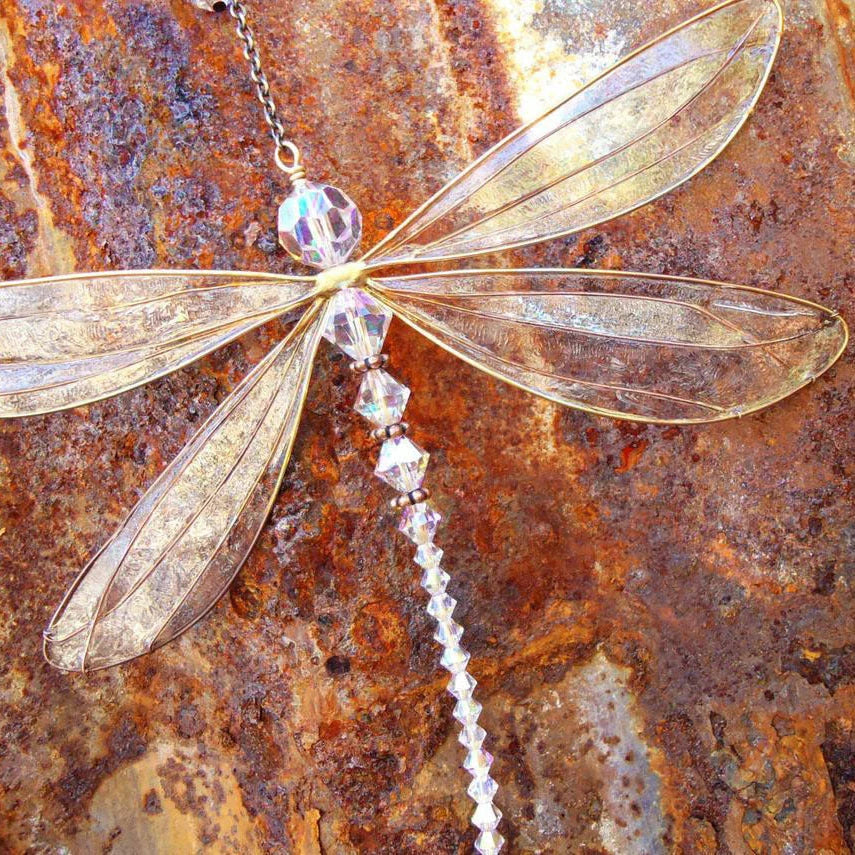 Dragonfly-shaped crystal suncatcher that creates a vibrant rainbow display when exposed to sunlight, perfect for garden, wedding and home decor