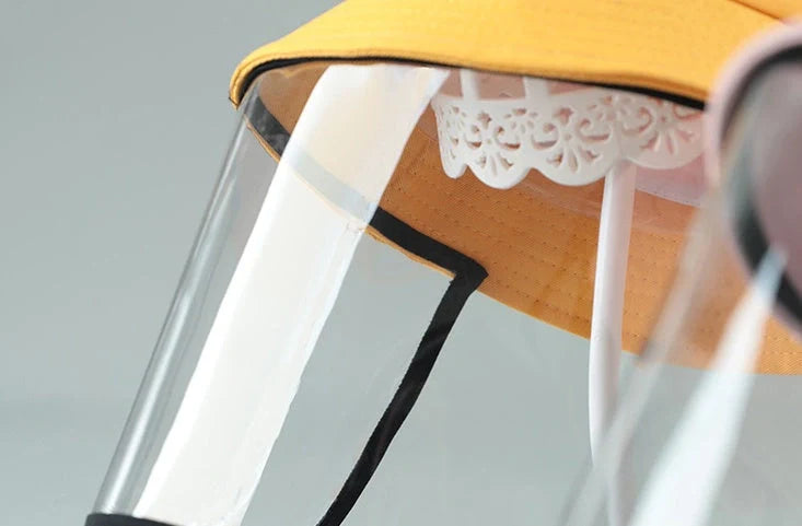 Child wearing anti-spitting protective hat with transparent bezel