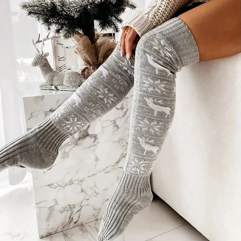 Cozy Christmas knee-high socks for women featuring a festive snowflake and reindeer pattern, designed to provide warmth and comfort during the winter season.